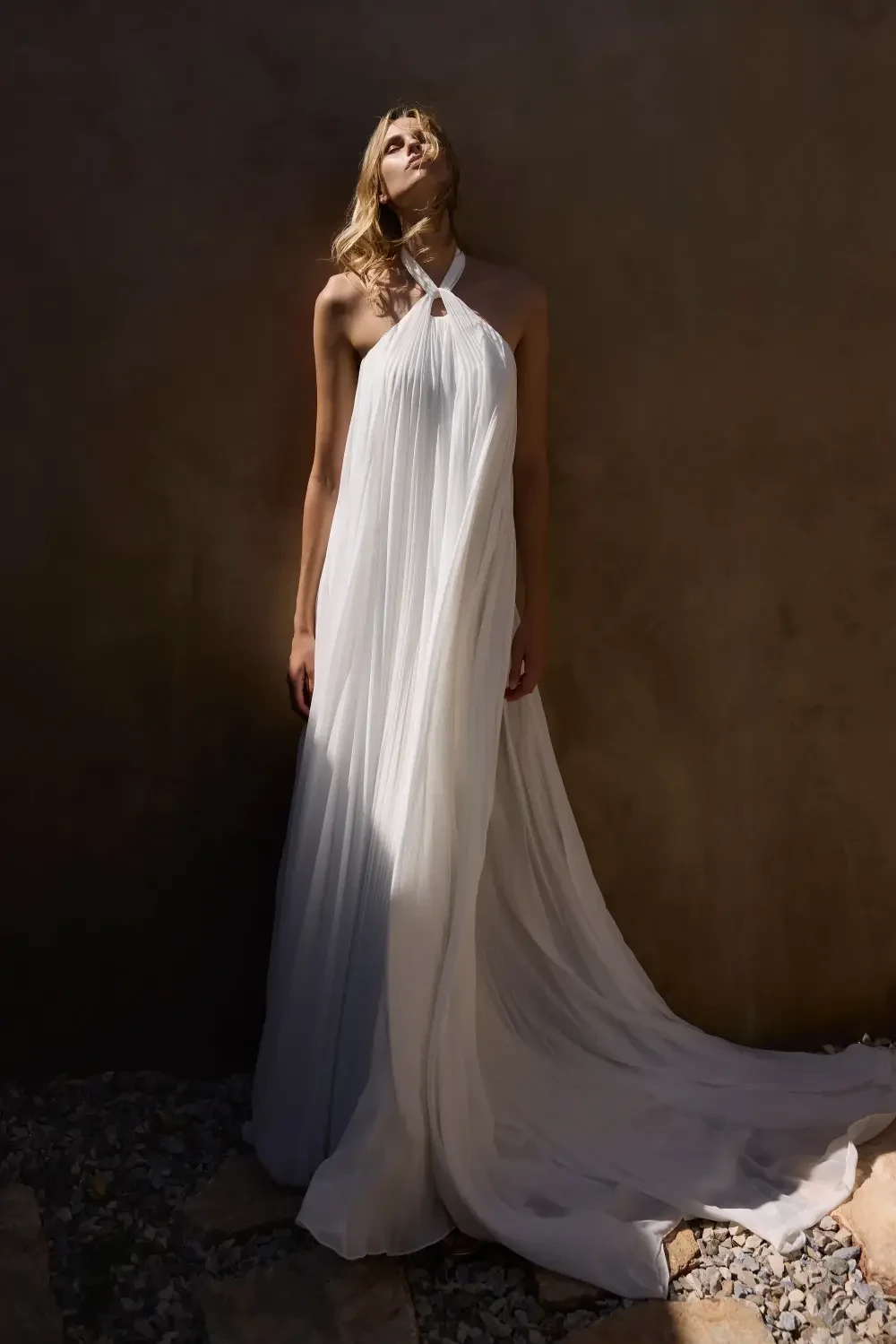 model is wearing a breezy sleeveless bridal gown