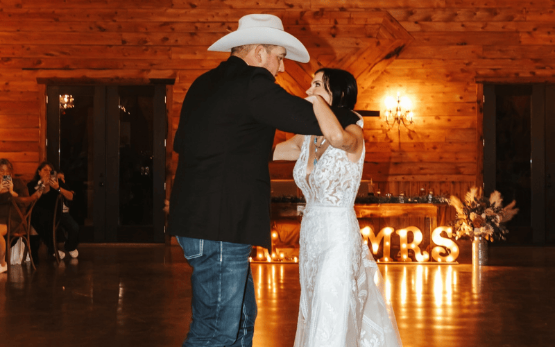 bride wearing a sheath second wedding dress at a dance with partner