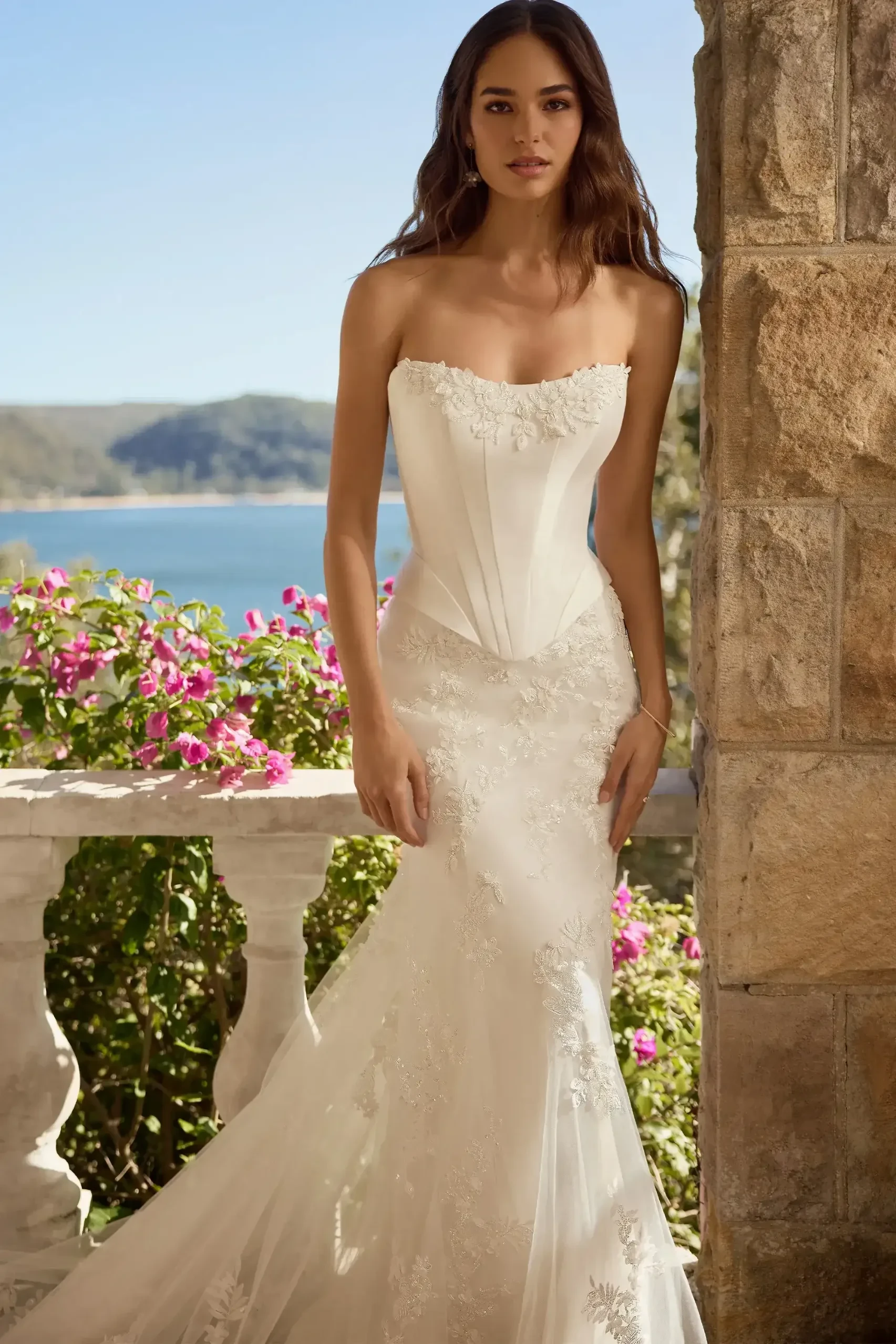 Model wearing a white gown by Sophia Tolli