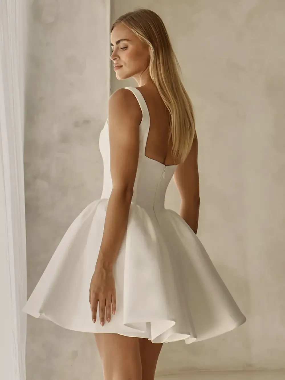 model is wearing a sleeveless mini bridal gown
