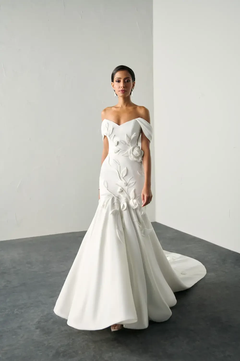 model is wearing an off the shoulder bridal gown
