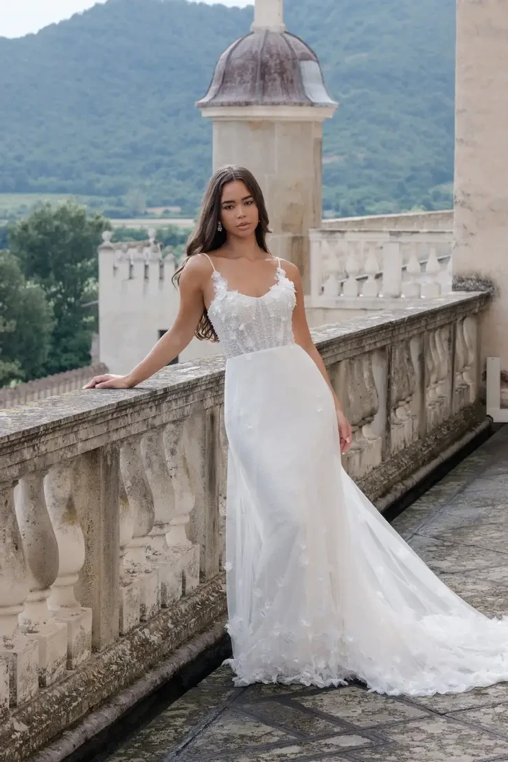Bride wearing a soft tulle wedding dress with a sheer floral bodice and subtle appliqué details at