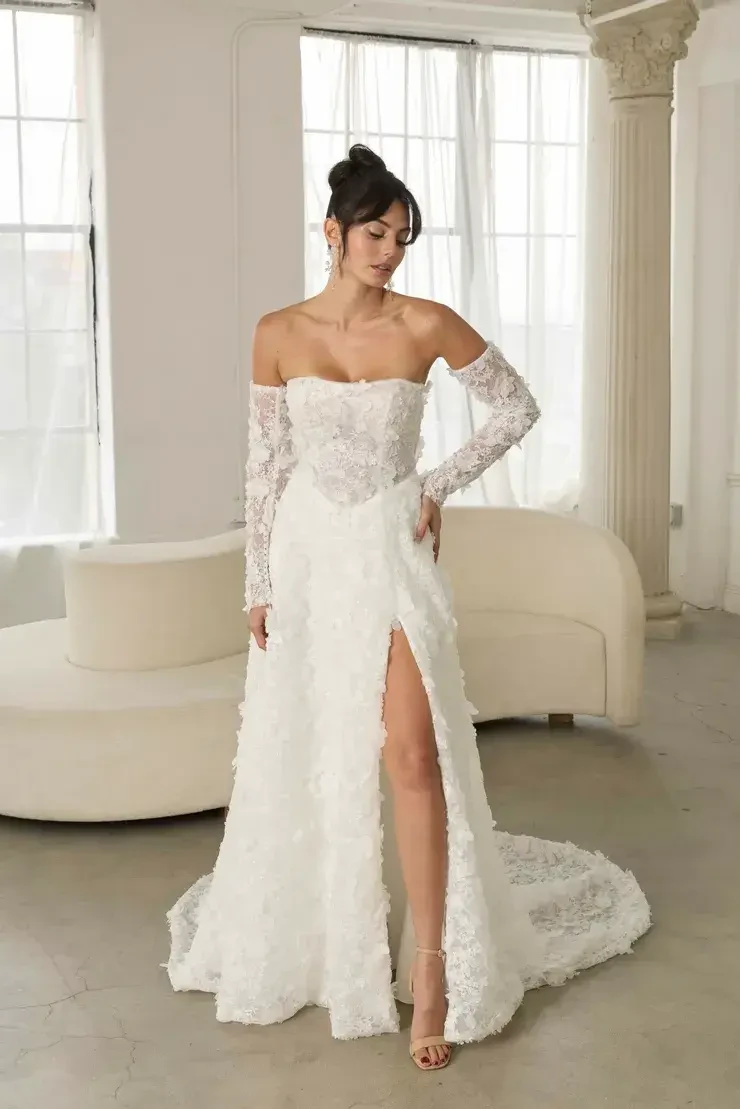 Bride wearing a long sleeve lace off-the-shoulder wedding dress with a thigh-high slit at Babe